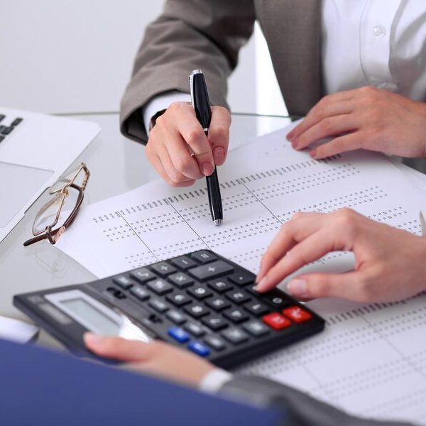 two-female-accountants-counting-calculator-income-tax-form-completion-hands-closeup-internal-revenue-service-inspector-checking-financial-document-planning-budget-audit-concept_665183-455